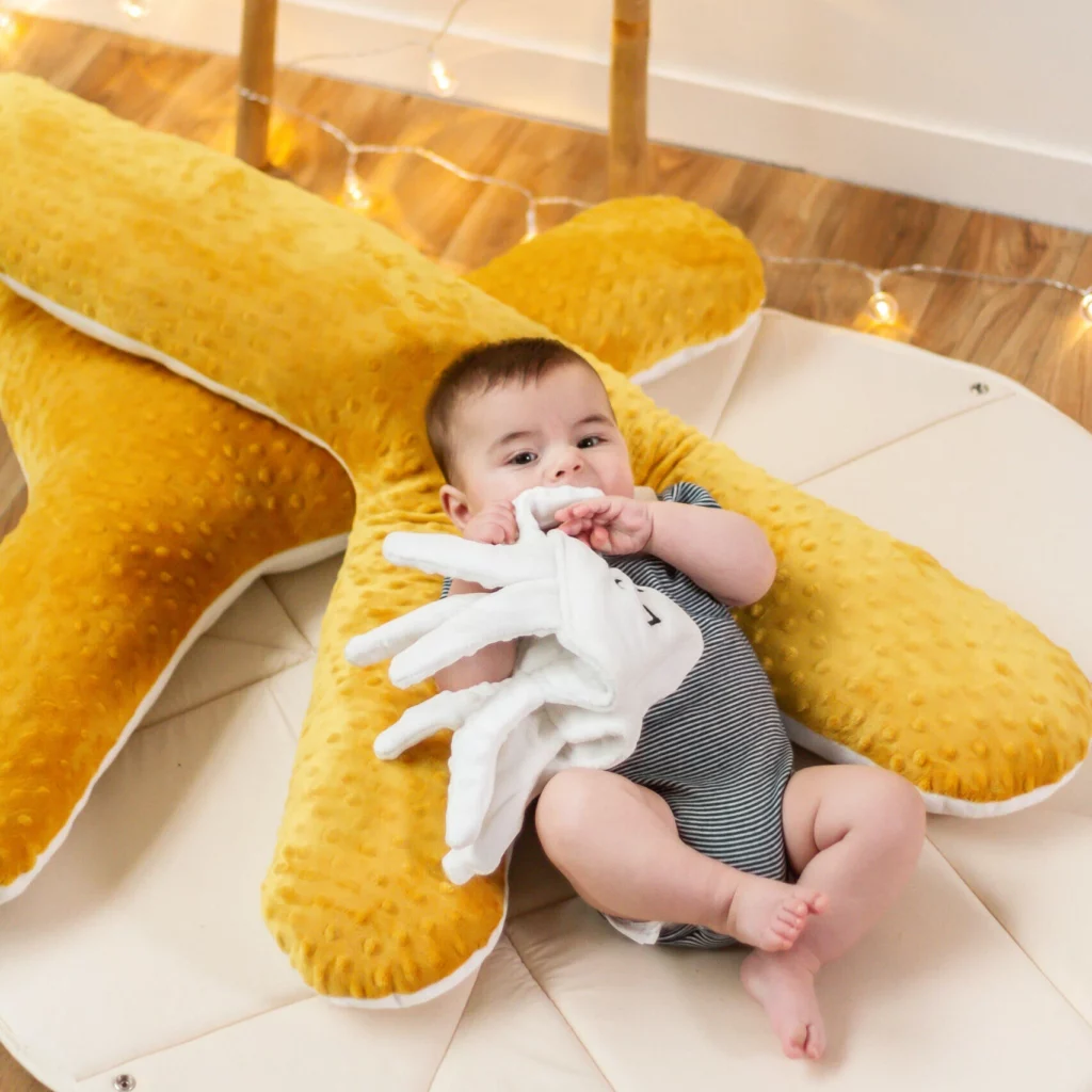 Enfant assis dans un coussin jaune en forme de corail