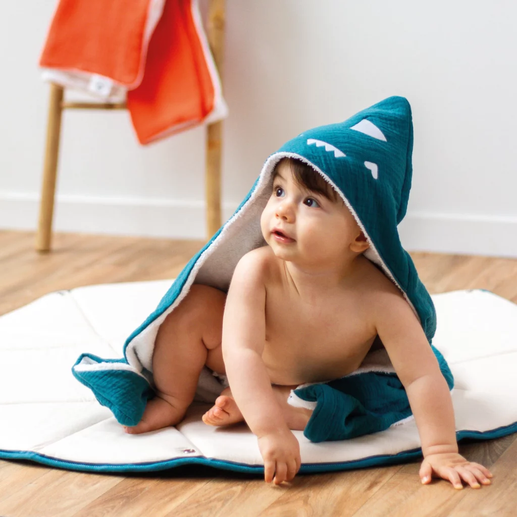 Enfant avec une cape de bain bleu Toupli sur la tête