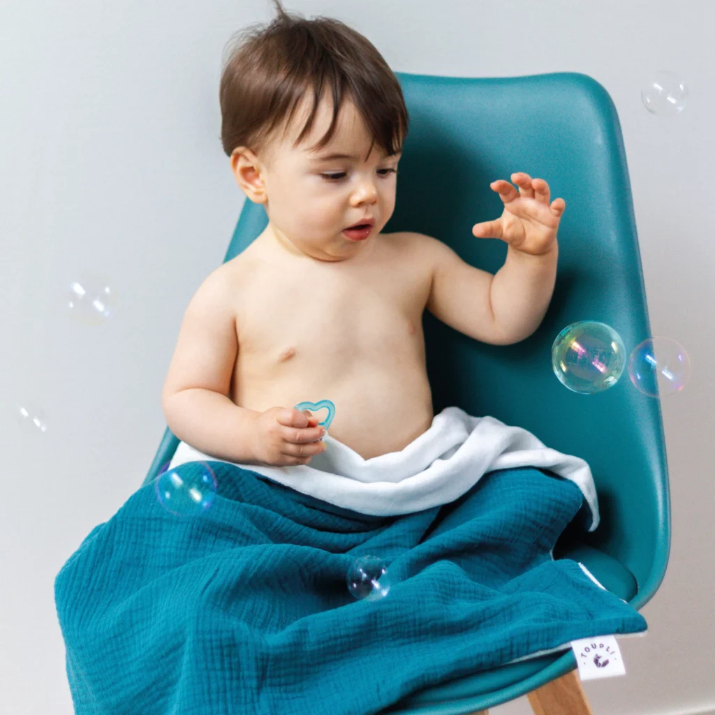 Bébé enveloppé dans un plaid bleu Toupli